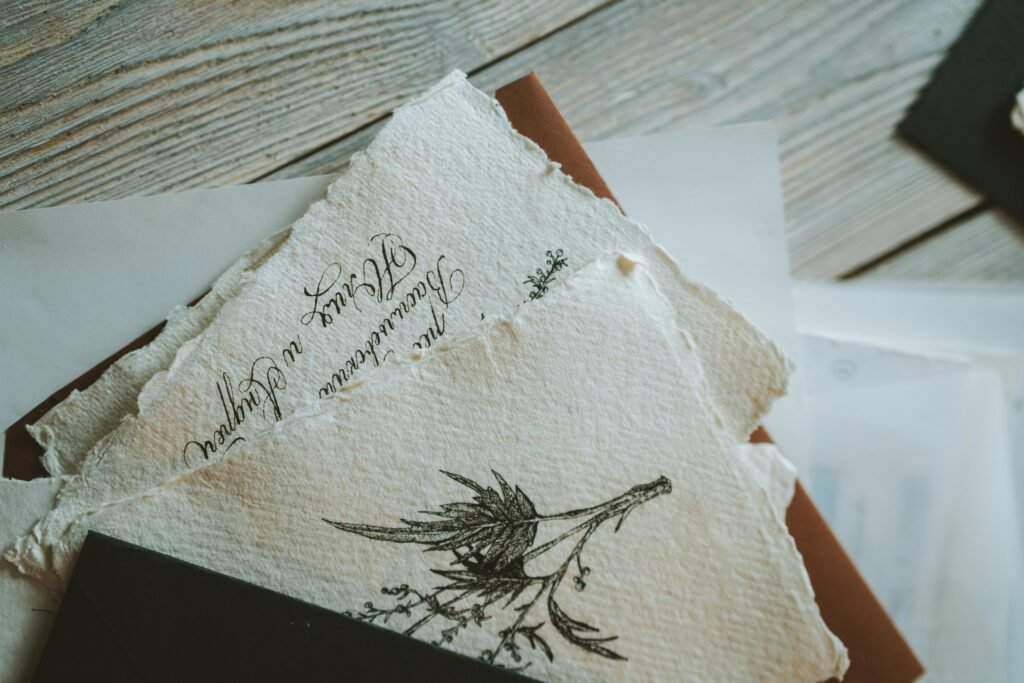 Artistic postcards with handwritten text and floral illustrations on a wooden table.
